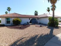 Spanish-style home with attractive landscaping at 9867 W Roundup Ct, Sun City, AZ 85373