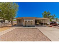 Tan single wide mobile home with covered carport at 8125 E Billings St, Mesa, AZ 85207