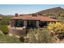 Stunning Spanish-style home with a tiled roof, stone accents, and a large patio at 9975 E Broken Spur Dr, Scottsdale, AZ 85262