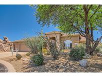 Tan house with a two-car garage and desert landscaping at 9768 E Balancing Rock Rd, Scottsdale, AZ 85262