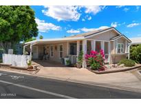 Tan manufactured home with porch and landscaped yard at 8865 E Baseline Rd # 531, Mesa, AZ 85209