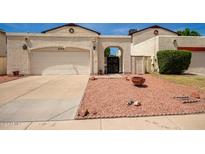 Front view of a tan house with a two-car garage and a landscaped yard at 4760 W Wahalla Ln, Glendale, AZ 85308