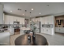 Modern kitchen with white cabinets and a large island at 1859 N Westfall Ln, Casa Grande, AZ 85122