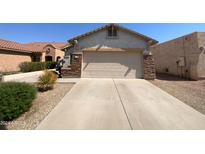 Front view of a single-story home with a two-car garage and stone accents at 11168 E Lost Canyon Ct, Gold Canyon, AZ 85118
