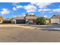 Single-story home with red door and black garage door at 3406 E Libby St, Phoenix, AZ 85032