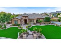 Stunning home with a lush green lawn and mountain views at 7054 E Ingram St, Mesa, AZ 85207