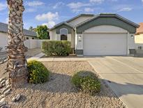 House exterior featuring a two car garage and desert landscaping at 6447 W Escuda Rd, Glendale, AZ 85308
