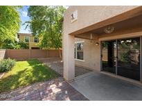 Landscaped backyard with grassy area and patio at 11009 W Elm St, Phoenix, AZ 85037