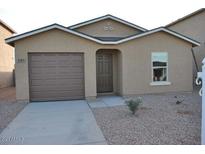 Tan house with brown garage door and small yard at 137 E Douglas Ave, Coolidge, AZ 85128