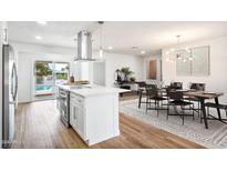 Modern kitchen with island, dining area, and hardwood floors at 9310 W Manzanita Dr, Sun City, AZ 85373