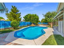 Inviting kidney-shaped pool with a painted wall backdrop at 4020 W Anderson Dr, Glendale, AZ 85308