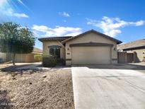 House exterior showcasing a single-story home with a two-car garage and desert landscaping at 42054 W Cheyenne Dr, Maricopa, AZ 85138