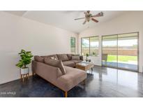 Relaxing living room with L-shaped sectional sofa and sliding doors to backyard at 35066 N Happy Jack Dr, San Tan Valley, AZ 85144