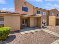 Tan two-story stucco condo with double doors and small front yard at 3511 E Baseline Rd # 1031, Phoenix, AZ 85042