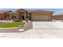 Tan house with a three-car garage and landscaped front yard at 11225 E Ocaso Ave, Mesa, AZ 85212