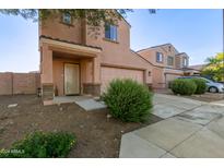 Two-story house with tan exterior, two-car garage, and landscaping at 8690 S 253Rd Ave, Buckeye, AZ 85326