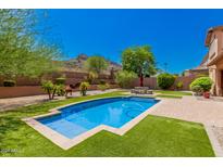Backyard oasis featuring a sparkling pool and lush landscaping at 5713 W Rowel Rd, Phoenix, AZ 85083