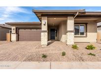 Inviting front yard with a two-car garage and a welcoming entryway at 21856 E Saddle E Ct, Queen Creek, AZ 85142