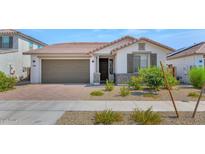 Single-story home with brown garage door, white exterior, and landscaping at 14454 W Faye Way, Surprise, AZ 85387