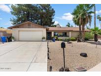 Beige house exterior with a two-car garage and landscaped yard at 3019 E Marilyn Rd, Phoenix, AZ 85032