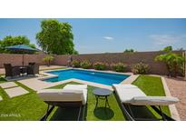 Inviting backyard oasis with a sparkling pool and lounge chairs at 4809 E Fire Opal Ln, San Tan Valley, AZ 85143