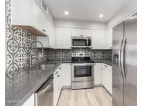 Modern kitchen with stainless steel appliances and stylish backsplash at 9275 E Mission Ln # 215, Scottsdale, AZ 85258