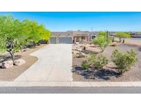 Single story home with three car garage and landscaped yard at 24702 W Red Robin Dr, Wittmann, AZ 85361