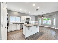 Spacious kitchen with granite island, white cabinets, and wood-look flooring at 654 S Sabrina --, Mesa, AZ 85208
