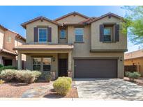 Two-story house with a green facade, brown garage door, and landscaped yard at 2527 W Brookhart Way, Phoenix, AZ 85085