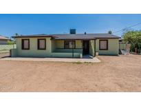 Light green single story home with a small front yard at 1517 W Sahuaro Dr, Phoenix, AZ 85029