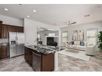 Open concept kitchen with an island, stainless steel appliances, and views to the living room at 3407 E Glacier Pl, Chandler, AZ 85249
