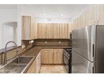 Modern kitchen with stainless steel appliances and wood cabinets at 6900 E Princess Dr # 2221, Phoenix, AZ 85054