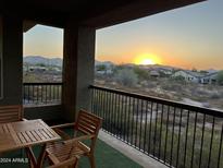 Sunset view from a patio with wooden table and chairs at 2425 W Bronco Butte Trl # 2017, Phoenix, AZ 85085