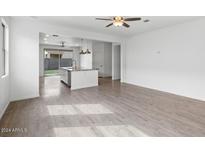 Bright living room with hardwood floors and ceiling fan at 21451 W Palm Ln, Buckeye, AZ 85396