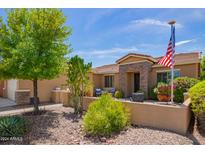 Single-story home with landscaped front yard and American flag at 20980 N Sweet Dreams Dr, Maricopa, AZ 85138