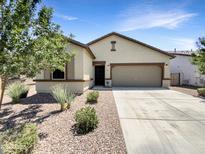 Single story home with two car garage and desert landscaping at 311 W Powell Dr, San Tan Valley, AZ 85140