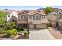 Two-story house with solar panels, landscaped yard, and a three-car garage at 5116 W Trotter Trl, Phoenix, AZ 85083