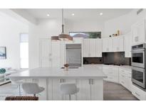 Modern white kitchen with large island and stainless steel appliances at 13778 E Charter Oak Dr, Scottsdale, AZ 85259