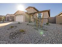 New construction home with a two-car garage and desert landscaping at 37343 W Patterson St, Maricopa, AZ 85138