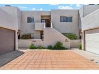 Tan stucco building with two units, each with a garage and shared courtyard at 3059 E Rose Ln, Phoenix, AZ 85016