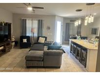 Open concept living room with kitchen island and seating at 40143 W Curtis Way, Maricopa, AZ 85138