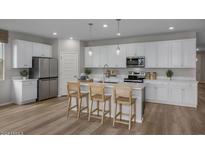 Modern kitchen with white cabinets, stainless steel appliances, and island at 3035 W Thurman Dr, Laveen, AZ 85339
