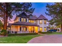 Two-story home with a wrap-around porch, and mature trees at 902 E San Angelo Ave, Gilbert, AZ 85234