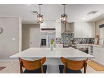 Kitchen island with white countertop and mid-century modern chairs at 2520 E Flower St, Phoenix, AZ 85016