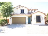 Two-story house with tan exterior and teal door at 36181 W Olivo St, Maricopa, AZ 85138