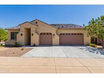 Tan two-story house with a three-car garage and desert landscaping at 707 W Coles Rd, Phoenix, AZ 85041