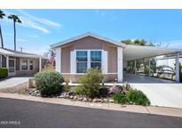 Single-wide manufactured home with carport and landscaping at 201 S Greenfield Rd # 11, Mesa, AZ 85206