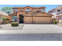 Two story house with three car garage and desert landscaping at 14867 W Windsor Ave, Goodyear, AZ 85395