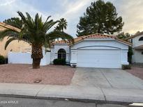White house with a two-car garage and palm tree at 1563 S Pennington Dr, Chandler, AZ 85286