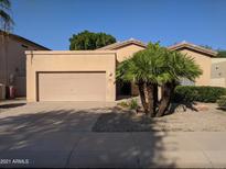 Single story home with a two car garage and desert landscaping at 15151 N 100Th Way, Scottsdale, AZ 85260